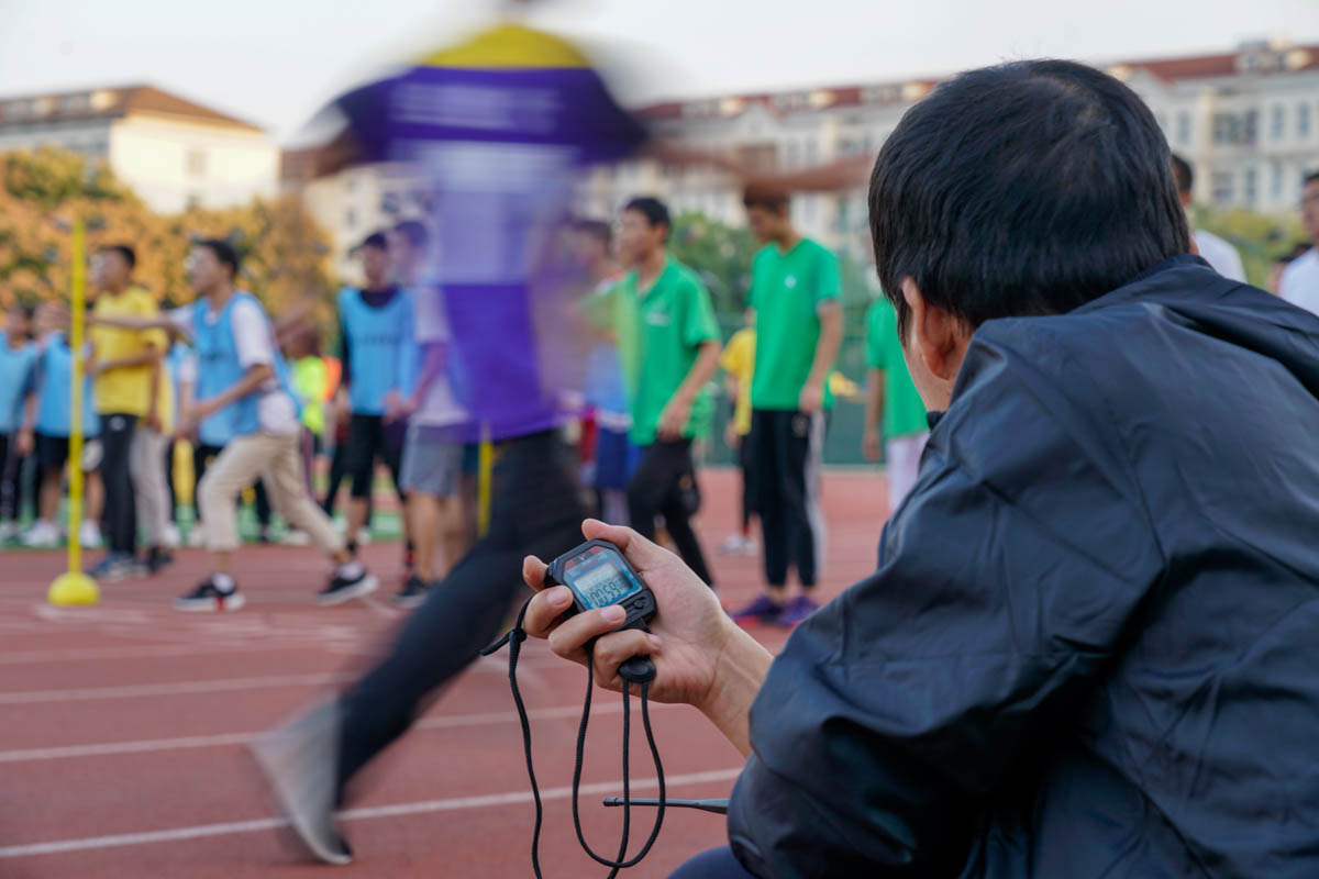 19男子15x50接力中，裁判员在运动员交接时掐下秒表【学通社记者 王梓安 摄】】